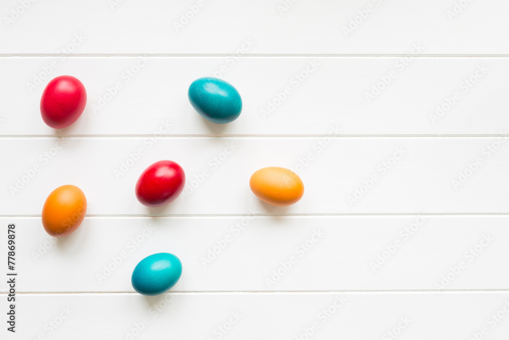 Easter eggs arrangement on white wooden background, top view