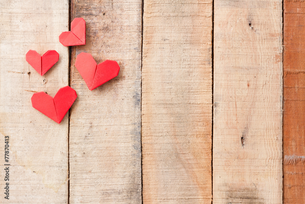 Origami hearts on wooden background with copy-space