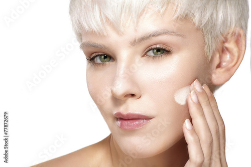 Beauty model applying cosmetic treatment  on her skin