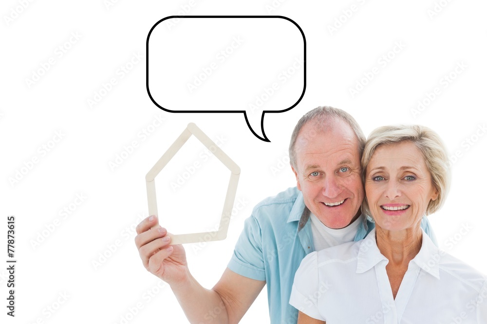 Composite image of happy older couple holding house shape Composite image of happy older couple holding house shape