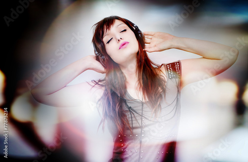 Konstfotografi Hermosa y joven mujer escuchando musica con auriculares