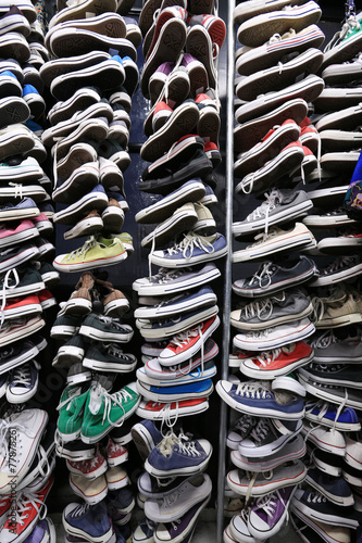 A large pile of old worn sneakers, shoes