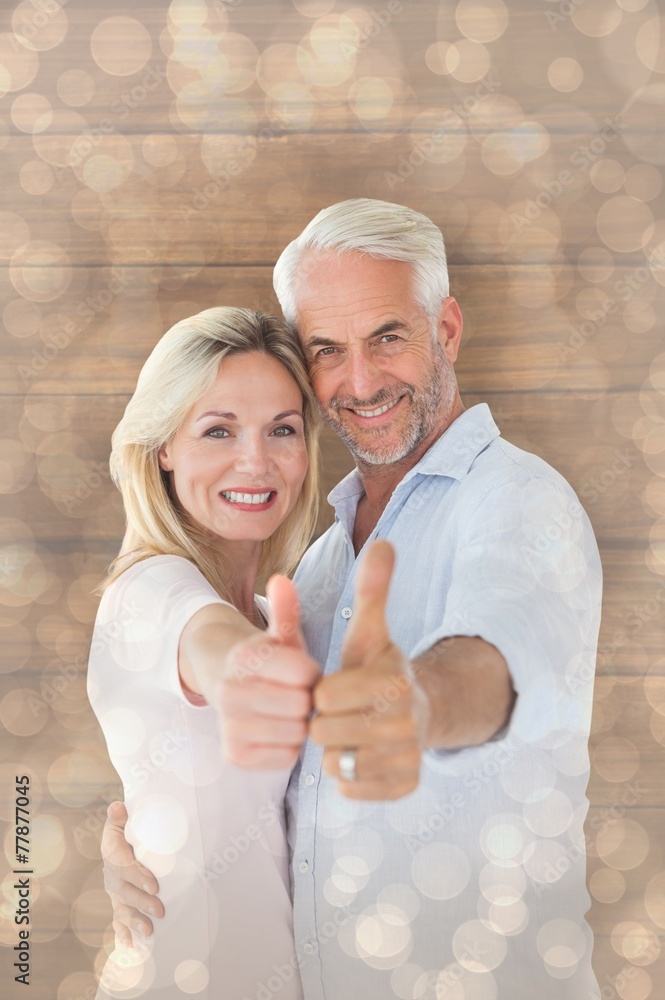 Composite image of smiling couple showing thumbs up together