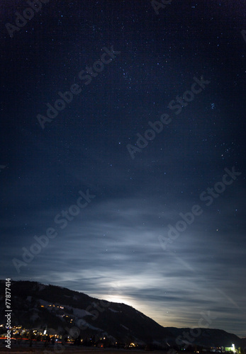 mountain silhouette against starry nigh sky and shining moon