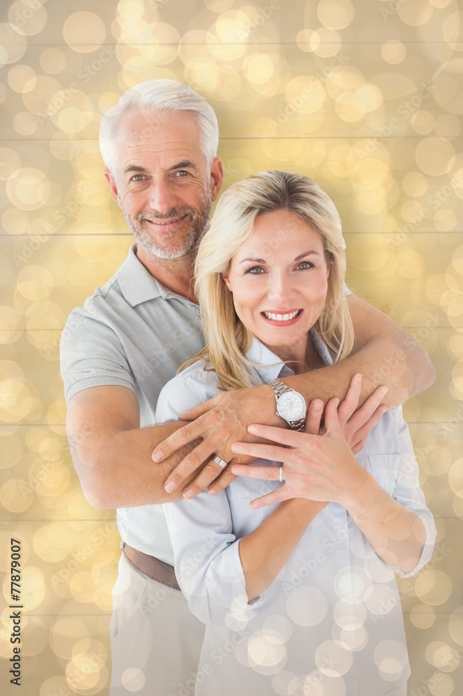 Composite image of happy couple smiling at camera and embracing