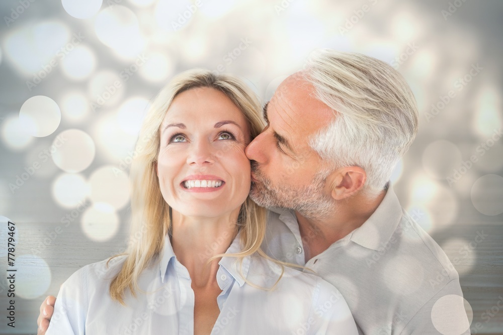 Affectionate man kissing his wife on the cheek Affectionate man kissing his wife on the cheek
