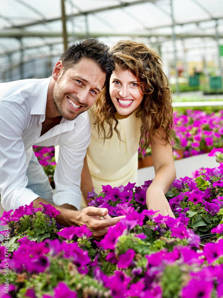 couple have fun choosing flower pots in a greenhouse