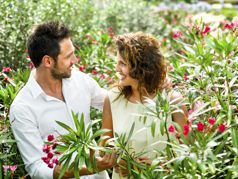 couple have fun choosing flower pots in a greenhouse