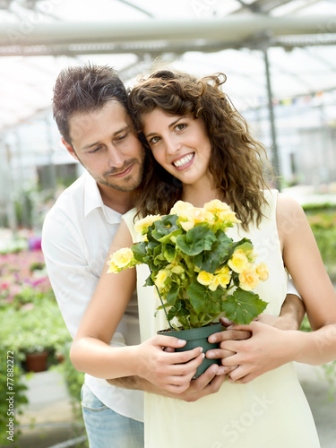 couple have fun choosing flower pots in a greenhouse