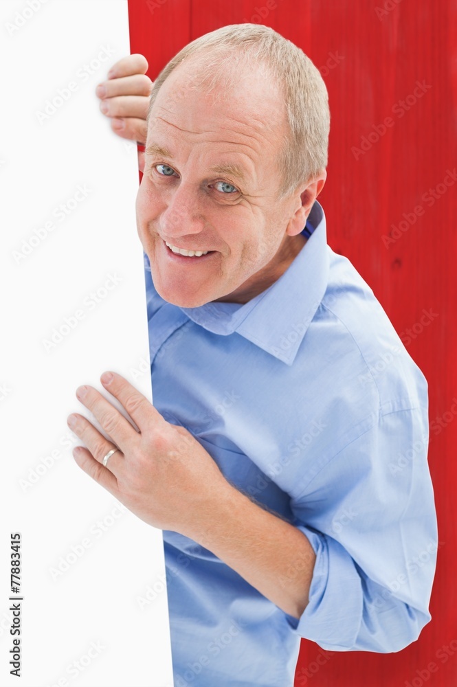 Composite image of mature man smiling at camera around card