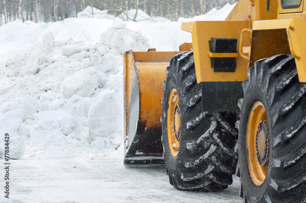 The bulldozer cleans the road after a blizzard The bulldozer cleans the road after a blizzard