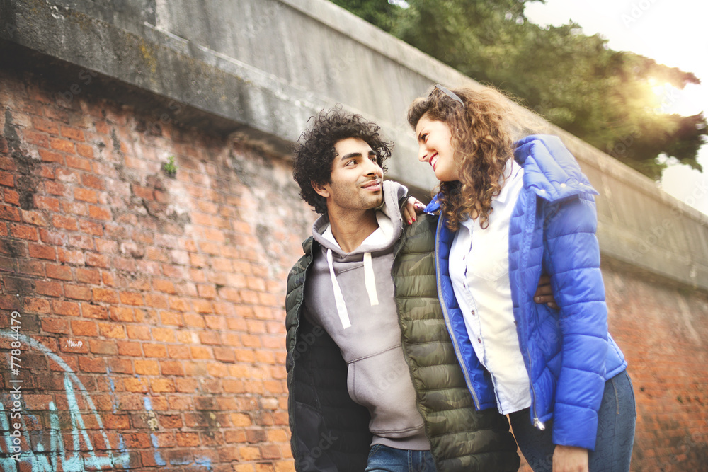 couple walking embraced around the city