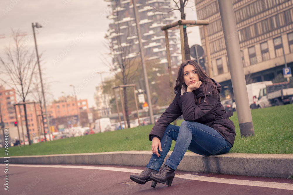Young beautiful girl posing in the city streets