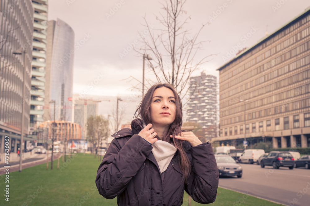 Fototapeta premium Young beautiful girl posing in the city streets