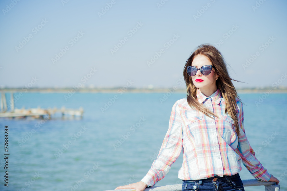 Young girl standing near the water 