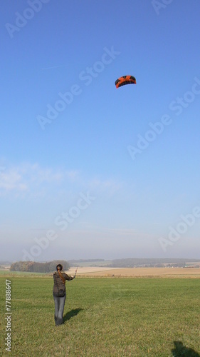 Girl flying a kite (landkiting) during sunny winter day
