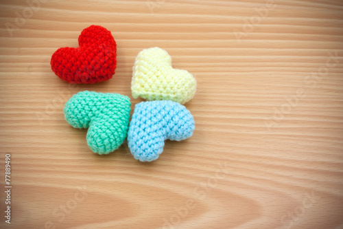 Colorful Yarn hearts on wood background