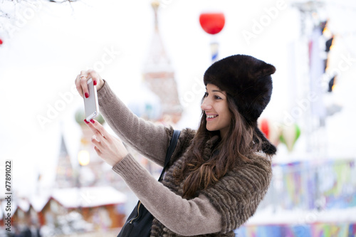 Young beautiful woman tourist taking pictures on mobile phone