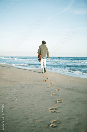 Lonely man walking on a beach at winter