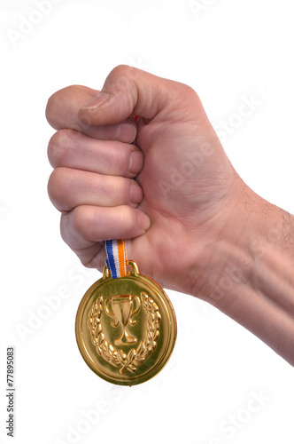 Vencedor celebrando triunfo sujetando una medalla de oro. photo