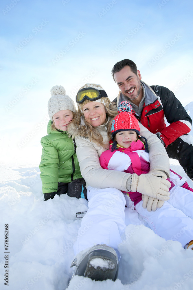 Cheerful family sitting in snow