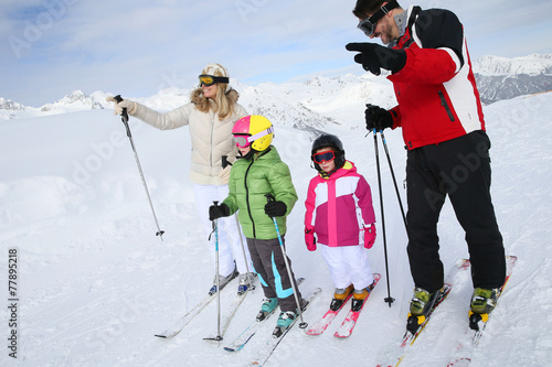 Family of four skiing together in winter