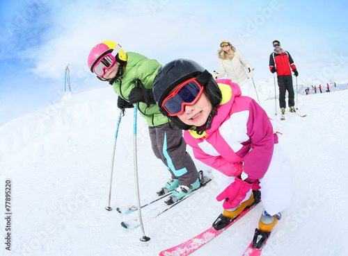 Young girl learning how to ski with family