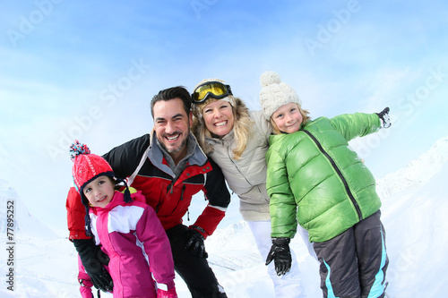 Cheerful family of 4 enjoying winter vacation