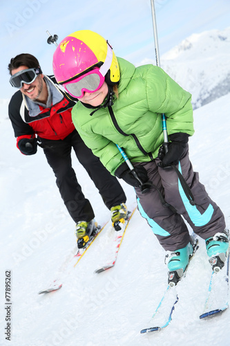 Daddy with young boy skiing down ski slope