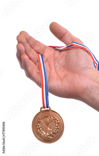 Vencedor celebrando triunfo sujetando una medalla de bronce. photo