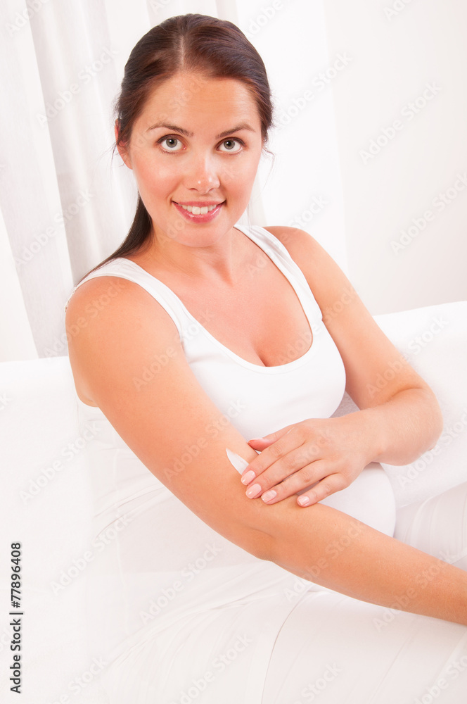 Pregnant woman applying cream on her body Pregnant woman applying cream on her body