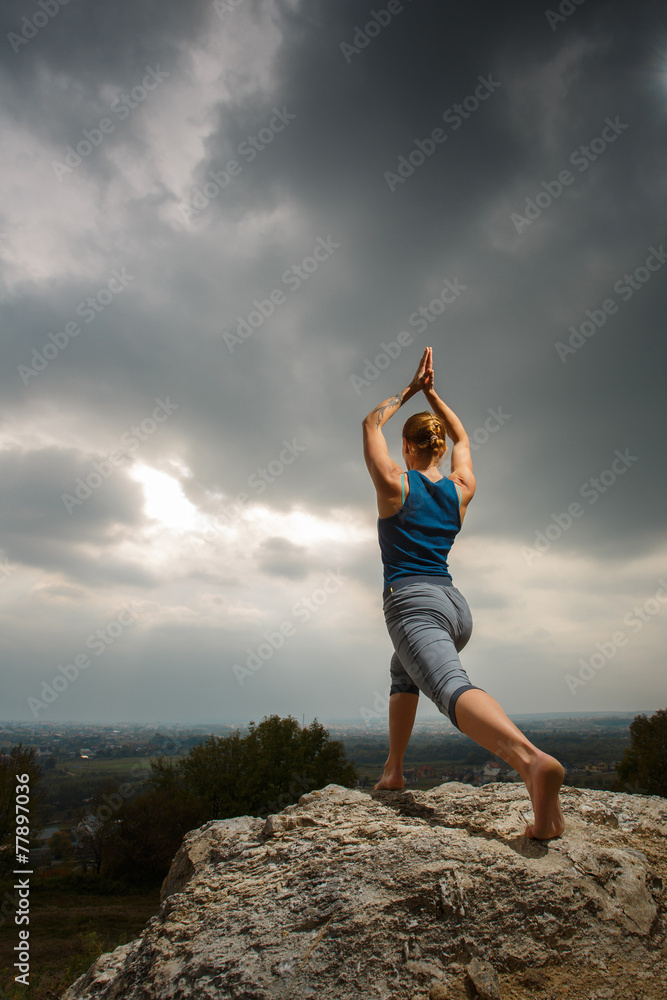 Woman doing yoga against the setting sun Woman doing yoga against the setting sun