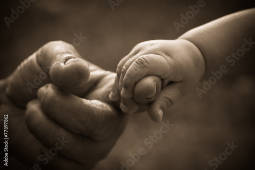 Baby hand holding mother finger with retro effect