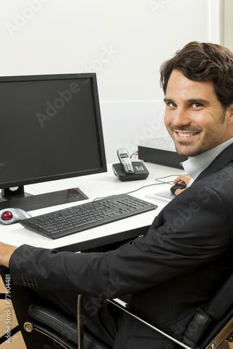 Stylish businessman in a suit sitting at his desk 