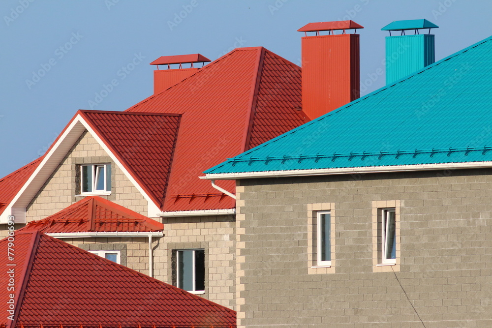 Cottages with red and blue roofs against a blue sky