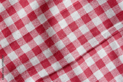Texture of a red and white crumpled picnic blanket.