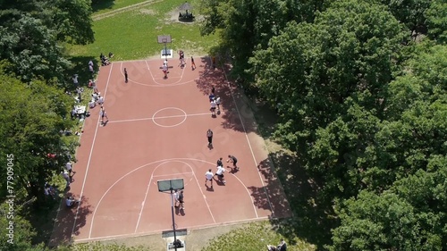 Aerial view on group of people playing basketball in local park.