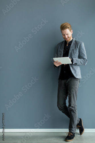 Man with tablet by the wall