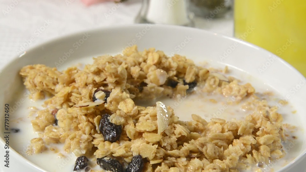 A spoonful of granola with nuts and raisins A spoonful of granola with nuts and raisins