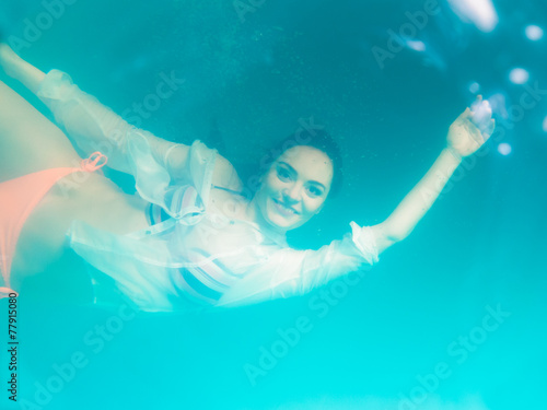 Underwater girl wearing bikini in swimming pool