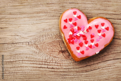 Heart shaped donut on wooden background