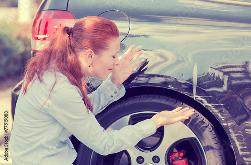 Frustrated woman checking pointing at car scratches dents