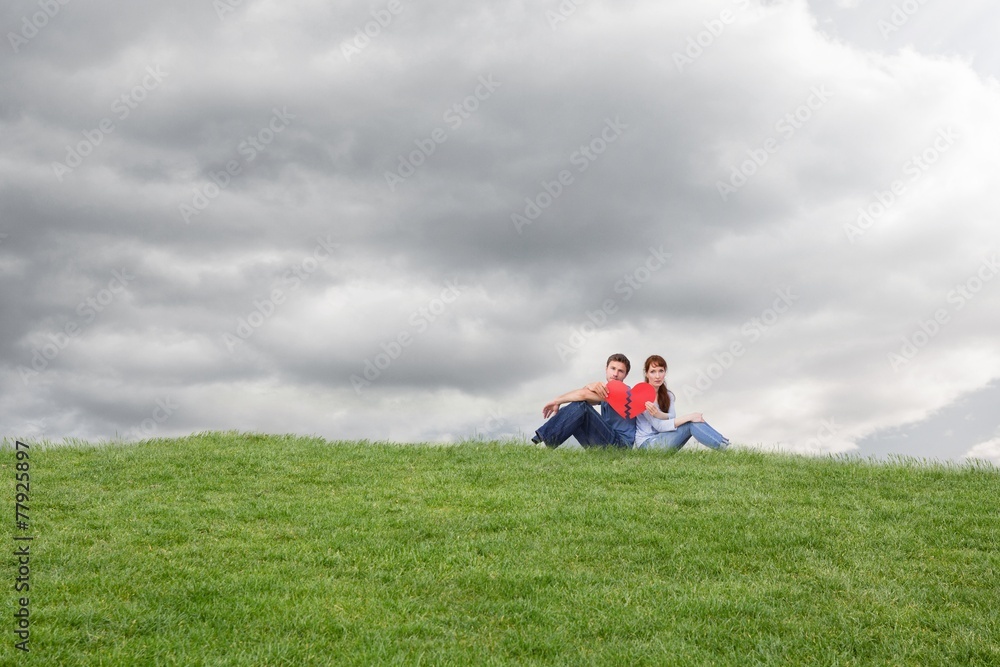 Composite image of couple holding a broken heart Composite image of couple holding a broken heart