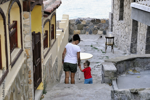 Son and mother walking on street of Ancient city Sozopol