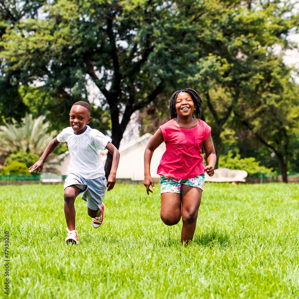 African kids running together in park.