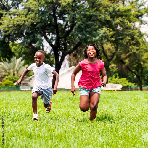 African kids running together in park.