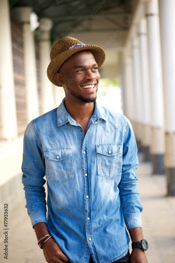 Trendy young man walking outside with hat Trendy young man walking outside with hat