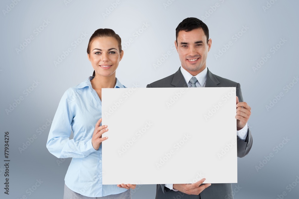 Composite image of business partners presenting sign Composite image of business partners presenting sign