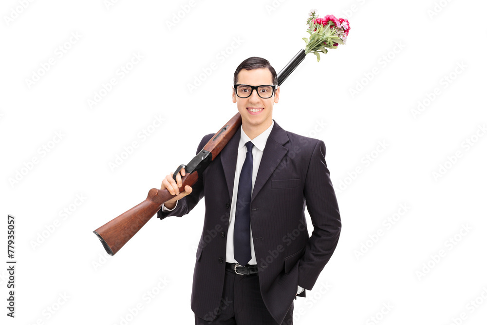 Businessman holding a rifle loaded with flowers