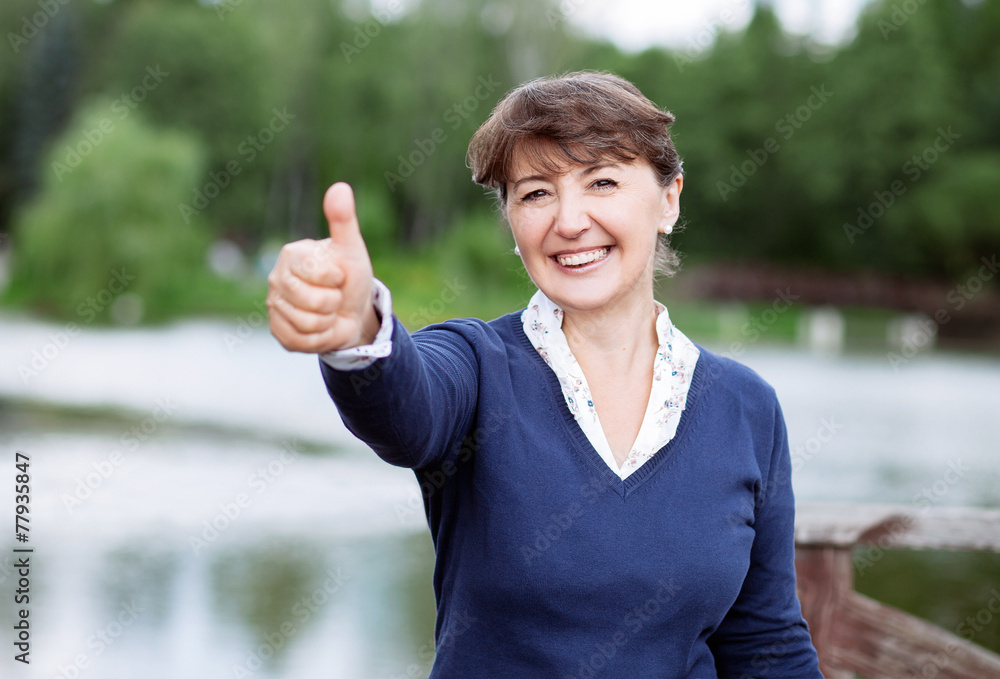 Attractive middle-aged woman giving a thumb up Attractive middle-aged woman giving a thumb up
